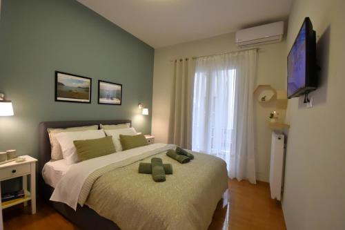 ein Schlafzimmer mit einem Bett mit zwei grünen Kissen darauf in der Unterkunft Sporades Apartment in Volos