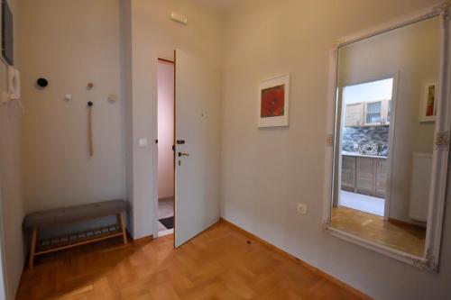 een lege kamer met een deur en een spiegel bij Sporades Apartment in Volos