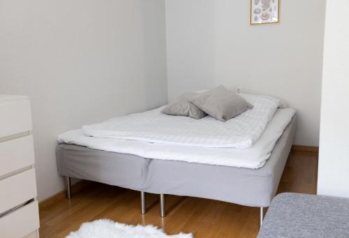 un letto in una camera con pareti bianche di 2ndhomes Cozy and Spacious Studio in Idyllic Katajanokka a Helsinki
