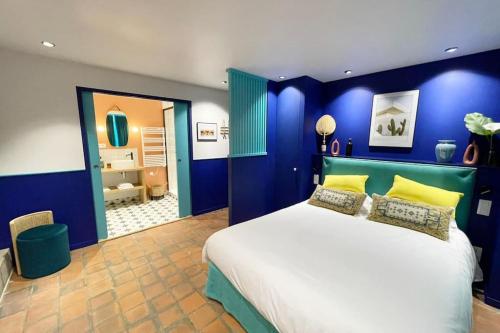 een slaapkamer met blauwe muren en een bed met gele kussens bij Chambre Majorelle - RDC - Plage 50m - Rue gratuite in Saint-Malo