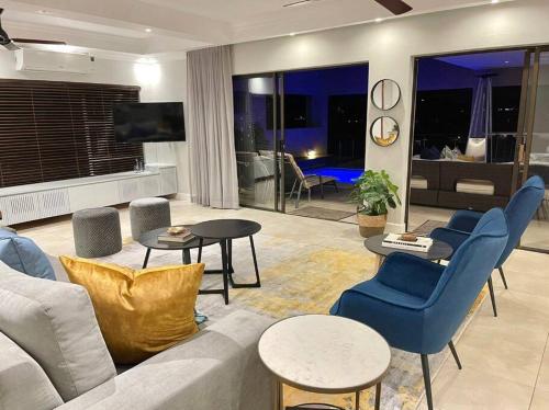 - un salon avec un canapé, des chaises et une télévision dans l'établissement The Windsor- Hartbeespoort Dam, à Hartbeespoort
