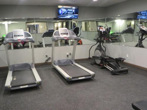 a gym with several exercise bikes and mirrors at Ivy Court Inn and Suites in South Bend