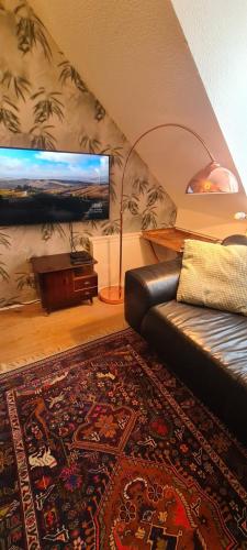 a living room with a couch and a piano at 3 Schlafzimmer &Wohnküche in Oberhausen