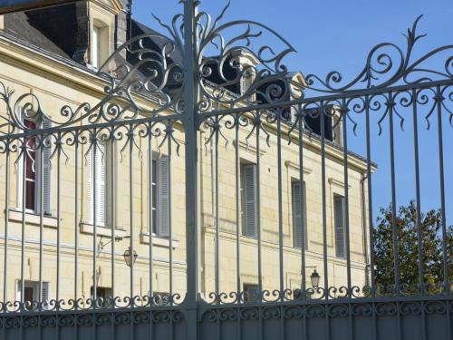 an ornate iron fence in front of a building at La Pénesais in Beaumont-en-Véron