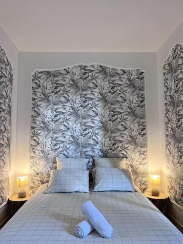 - une chambre avec un grand lit et du papier peint floral dans l'établissement Le Saumaise : Centre historique, à Dijon