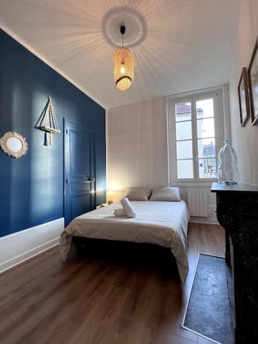 a bedroom with a bed and a blue wall at Le Saumaise : Centre historique in Dijon