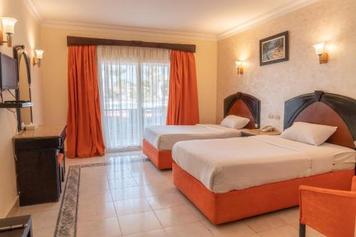 a hotel room with two beds and a television at Viva Sharm in Sharm El Sheikh