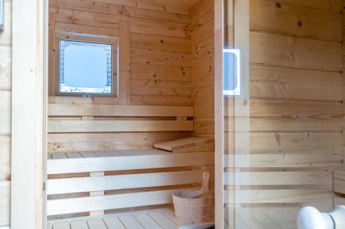 une cabane en bois avec un sauna et une fenêtre dans l'établissement Villapark Kamperfoelie 43, à De Koog
