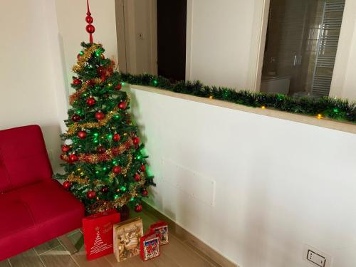 a christmas tree in a living room with a red couch at Caia Appartamenti Tropea in Tropea
