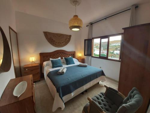1 dormitorio con 1 cama y 1 silla en Casa Isabel, en Betancuria