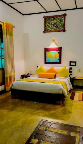 a bedroom with a large bed with yellow pillows at Train View Chalet in Bandarawela