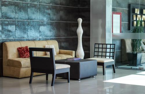 a living room with a couch and a table and chairs at Hotel Rio 1300 in Cuernavaca