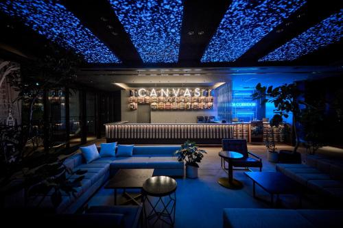 a lobby with a couch and a stage with blue lights at The Royal Park Canvas Ginza Corridor in Tokyo