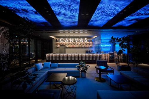 a lobby with a couch and a stage with blue lights at The Royal Park Canvas Ginza Corridor in Tokyo