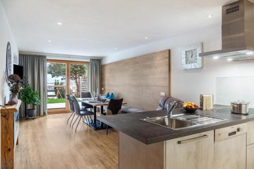 a kitchen and living room with a sink and a table at Apart-hochzillertal Gartenwohnung in Kaltenbach