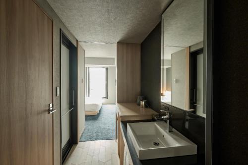 a bathroom with a sink and a mirror at The Royal Park Canvas Ginza Corridor in Tokyo