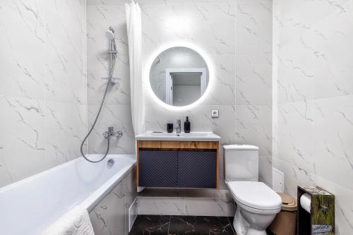 bagno con lavandino, servizi igienici e specchio di Raisson Ahotel GT79 a Astana