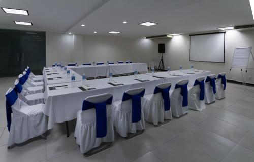 a conference room with white tables and blue chairs at Hotel Rio 1300 in Cuernavaca