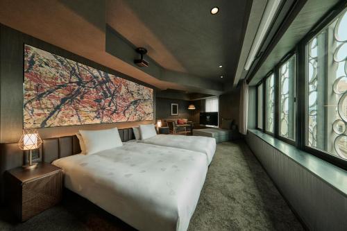 a bedroom with a large bed with a large painting on the wall at The Royal Park Canvas Ginza Corridor in Tokyo