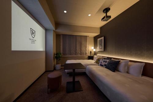 a hotel room with two beds and a couch at The Royal Park Canvas Ginza Corridor in Tokyo