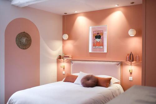 een slaapkamer met een groot wit bed met oranje muren bij Appartement Dunes - Plage 50m - Rue gratuite in Saint-Malo