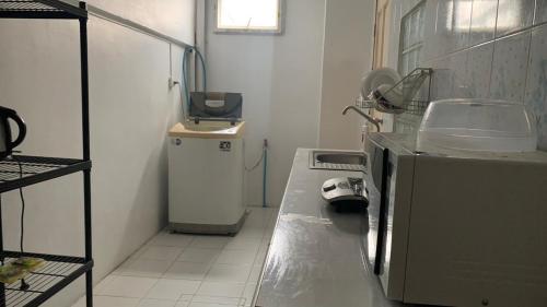 uma pequena cozinha com um lavatório e um micro-ondas em Min&Me House Pattaya em Nong Prue