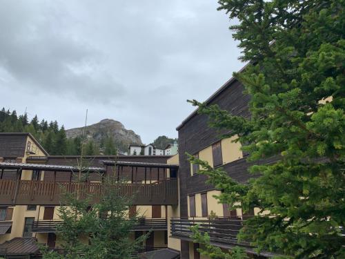 a building with a deck and stairs and a mountain at Chez Nous in Foppolo
