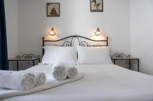 a bedroom with a white bed with towels on it at Studios Alsos in Naxos Chora
