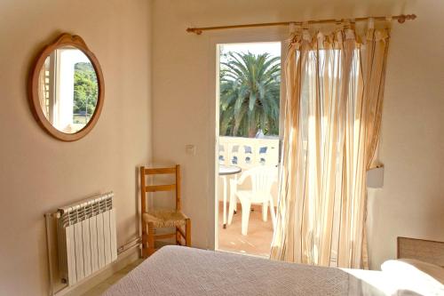 a bedroom with a bed and a window and a table at Fonda Las Palmeras in Font de Sa Cala