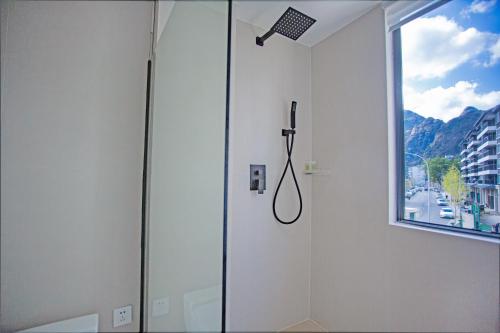 a shower with a shower head in a bathroom at IM Waiting Hotel in Yangshuo