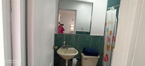 uma pessoa a tirar uma foto de uma casa de banho com um lavatório em Habitación Marlene em Cuenca