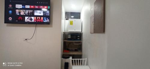 um quarto com uma cozinha com um micro-ondas e uma televisão em Habitación Marlene em Cuenca