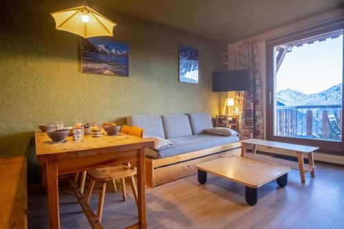 a living room with a couch and a table at Welcoming apartment in the Alpe d'Huez - Welkeys in LʼHuez