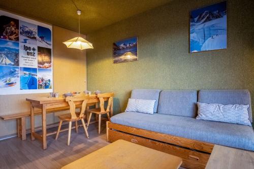 un salon avec un canapé et une table dans l'établissement Appartement El Santa - Welkeys, à Huez