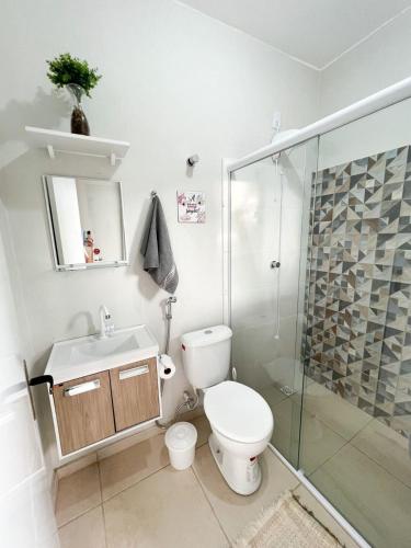 a bathroom with a toilet and a sink and a shower at Villa 61 | Hospedagem – Praia de Armação – Beto Carrero in Penha