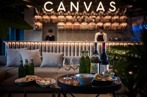 a table with wine glasses and food and wine bottles at The Royal Park Canvas Ginza Corridor in Tokyo