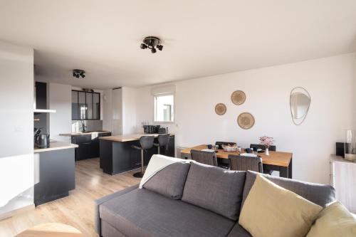 un salon avec un canapé et une salle à manger dans l'établissement Le Cocon Voltaire - Appartement 2 chambres avec parking - Mabilais, à Rennes