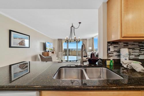 a kitchen with a sink and a living room at Perdido Sun 214 in Perdido Key