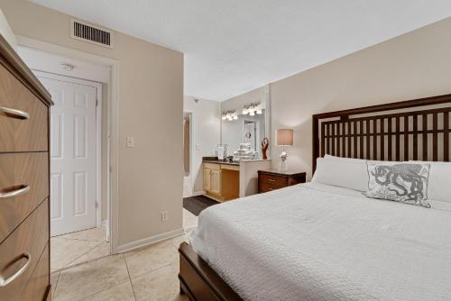 a bedroom with a bed and a dresser and a bathroom at Perdido Sun 214 in Perdido Key