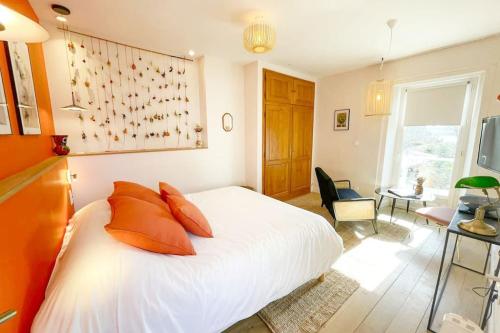 - une chambre avec un lit blanc et des oreillers orange dans l'établissement Appartement Frida - Plage 50m - Rue gratuite, à Saint-Malo