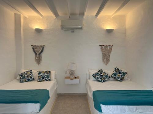 two beds in a room with white walls at Cabaña Doradal MILOS in Puerto Triunfo