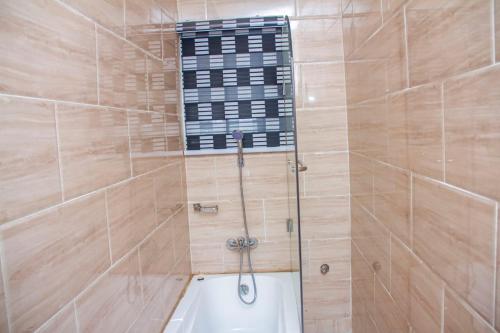 y baño con ducha y bañera. en House 13, Wuye Abuja, en Abuja