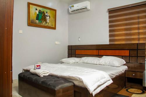 1 dormitorio con 1 cama grande y cabecero de madera en House 13, Wuye Abuja, en Abuja