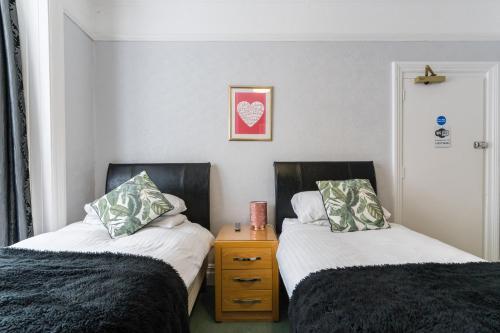 two beds sitting next to each other in a room at Rooms by Maes y mor Town Centre in Aberystwyth