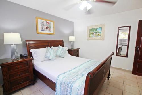 a bedroom with a bed and a dresser and lamp at Rosalie Apt #2 by BSL Rentals in Christ Church