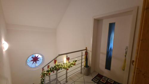 a hallway with a staircase with christmas lights and a window at Ferienwohnung Dreiseetal in Dorf Erbach