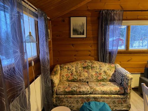a couch in the corner of a room with windows at Holiday House with beautiful scenery near Göta Kanal in Undenäs