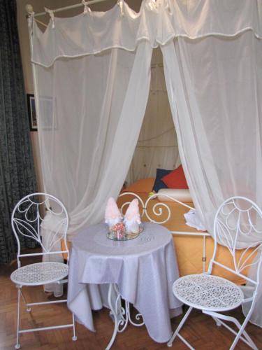 a room with a table and chairs and a bed at BB La Bella Addormentata e il Principe Calaf in Lucca