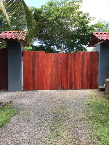 a wooden fence with a red gate in a yard at Jodokus Inn in Montezuma