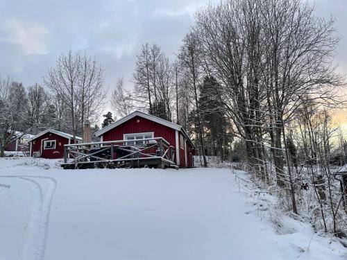 a red barn in the snow next to a road at Holiday House with beautiful scenery near Göta Kanal in Undenäs